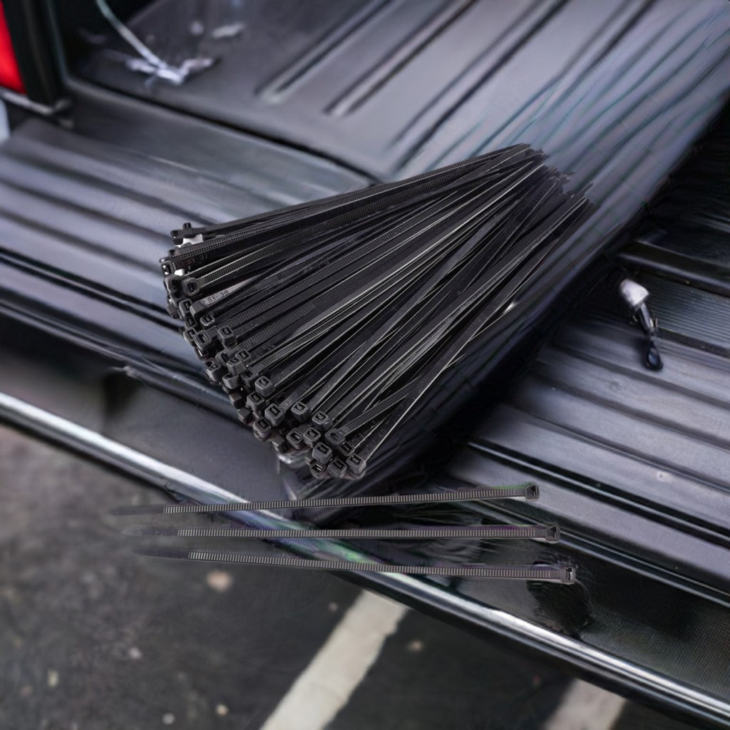 A 100-pack of 6-inch black heavy-duty zip ties, neatly bundled and placed on the back of a truck, ideal for organizing and securing items during transportation.